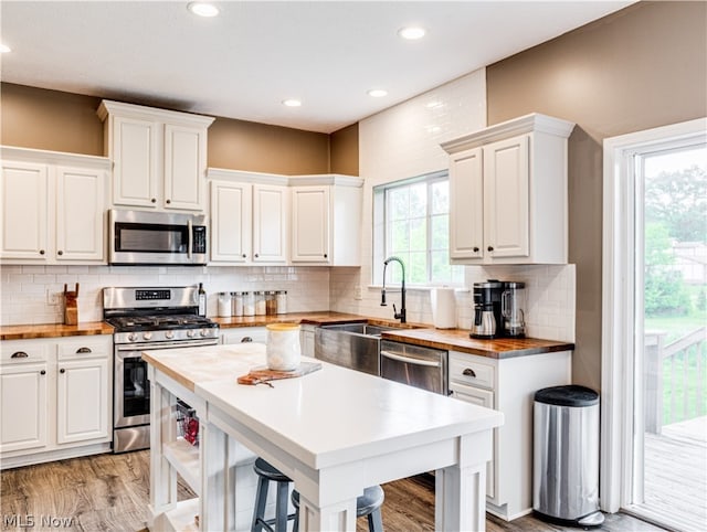 kitchen featuring appliances with stainless steel finishes, light hardwood / wood-style floors, and white cabinetry