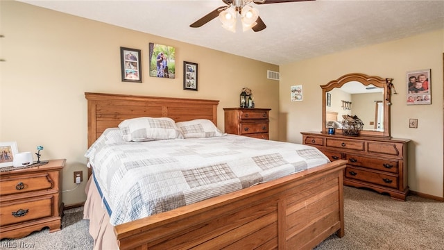 bedroom featuring carpet flooring, ceiling fan, and a textured ceiling