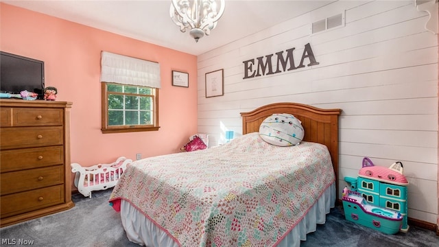 bedroom featuring an inviting chandelier and dark carpet