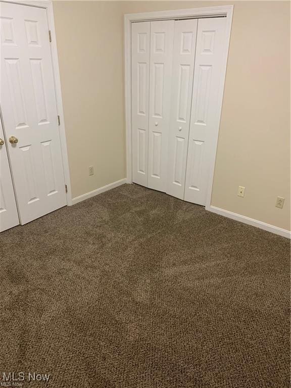 unfurnished bedroom featuring dark colored carpet