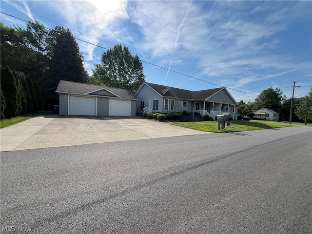 view of front of house featuring a garage, an outdoor structure, and a front lawn