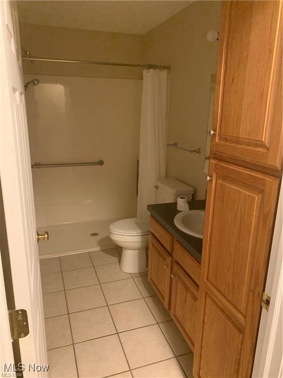 bathroom featuring tile patterned flooring, toilet, and curtained shower