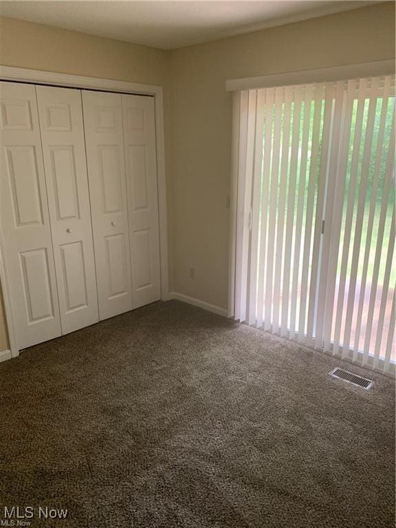 unfurnished bedroom featuring carpet and a closet