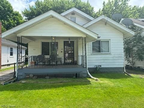 back of house featuring a lawn and covered porch