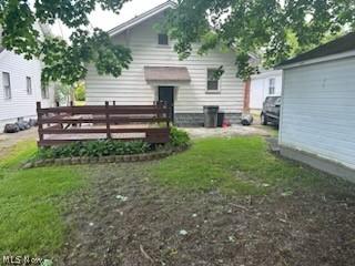 rear view of property featuring a wooden deck and a yard