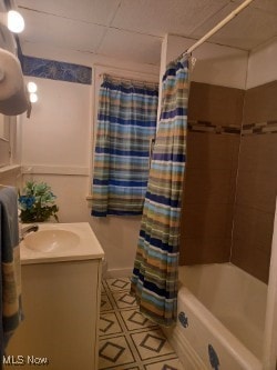 bathroom featuring vanity and shower / bathtub combination with curtain