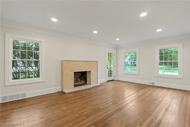 unfurnished living room with crown molding, a high end fireplace, and hardwood / wood-style flooring