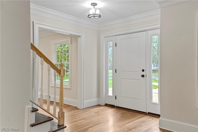 entryway featuring light wood-type flooring, plenty of natural light, and crown molding