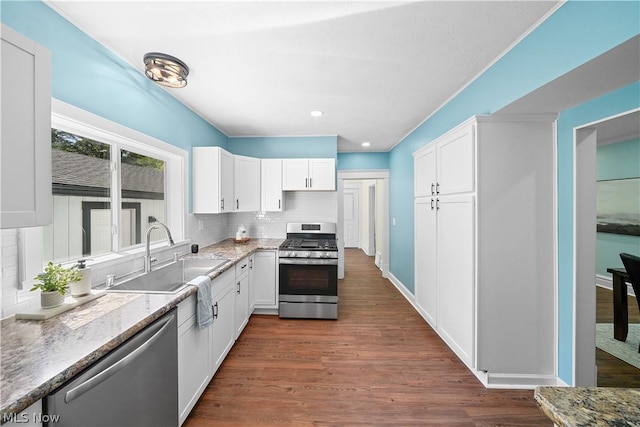 kitchen with dark hardwood / wood-style flooring, white cabinets, and stainless steel appliances