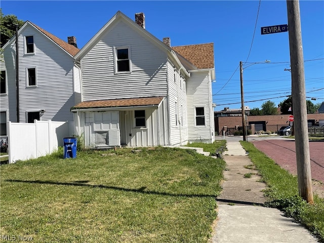 rear view of property with a yard