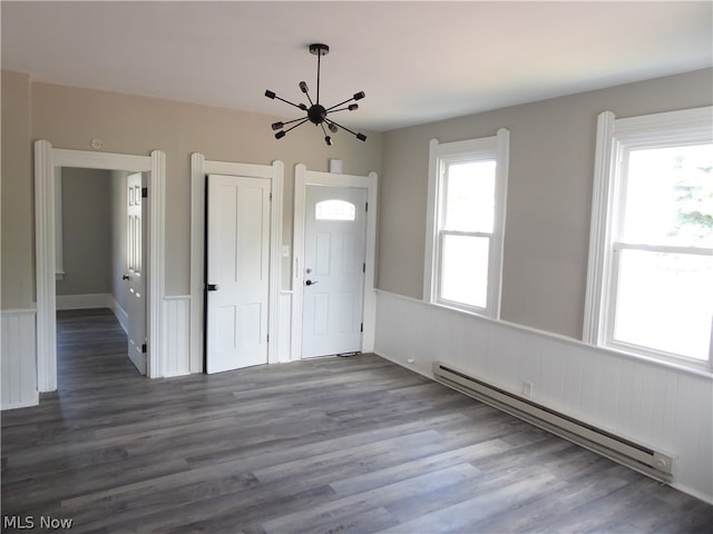 entryway featuring dark hardwood / wood-style flooring, an inviting chandelier, and a baseboard heating unit