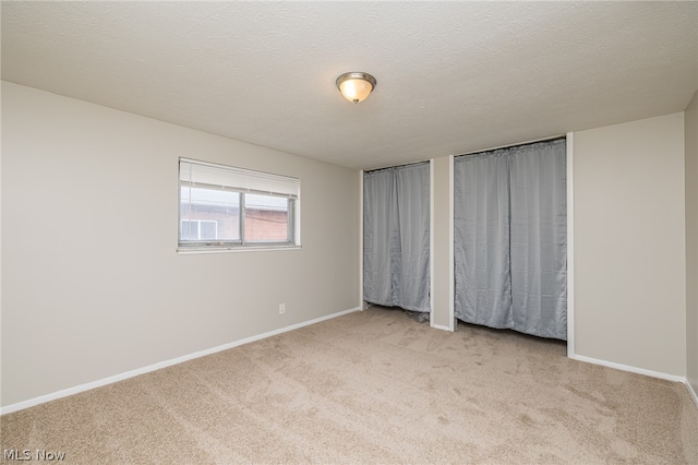 unfurnished bedroom with a textured ceiling and carpet floors