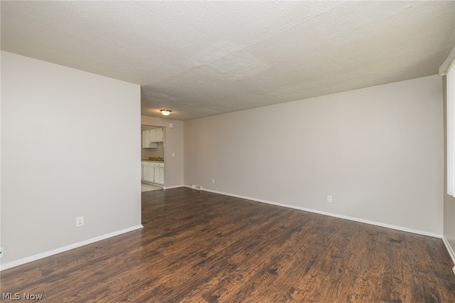 unfurnished room with a textured ceiling and hardwood / wood-style floors