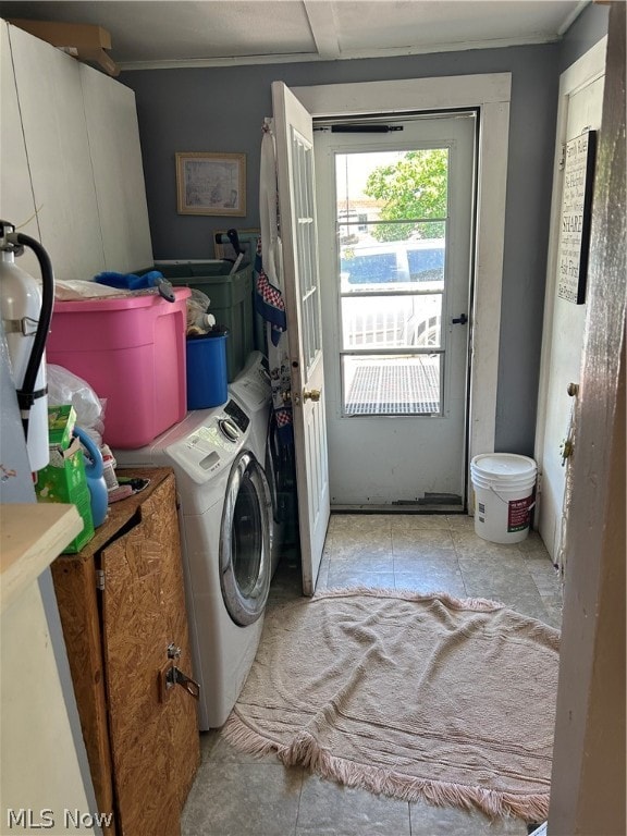 laundry room featuring washer / clothes dryer, crown molding, and cabinets