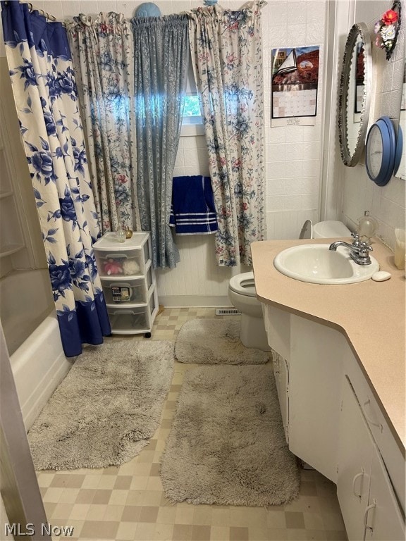 full bathroom with vanity, shower / bath combination with curtain, and toilet