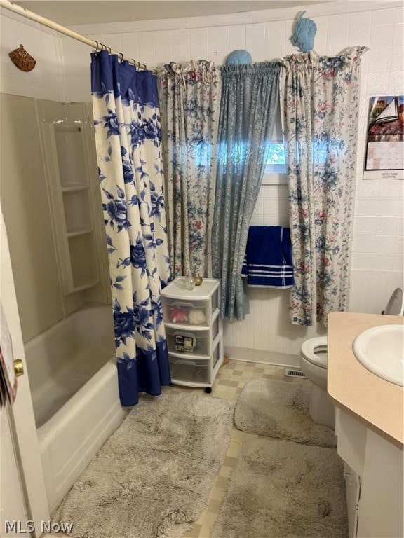 full bathroom with shower / bath combination with curtain, vanity, toilet, and tile patterned floors