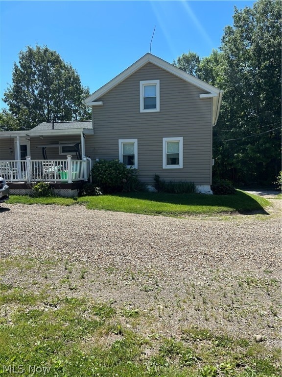 rear view of property featuring a wooden deck