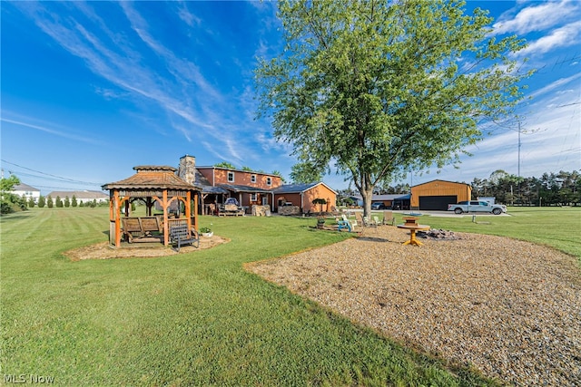 view of yard with a garage, a gazebo, and an outdoor structure