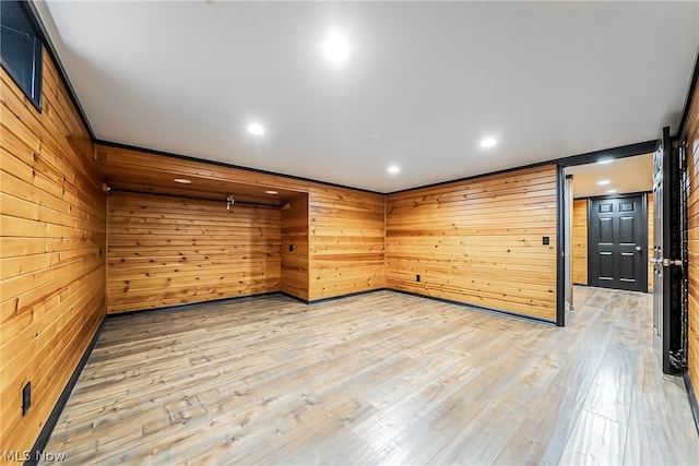 spare room featuring wood-type flooring and wood walls