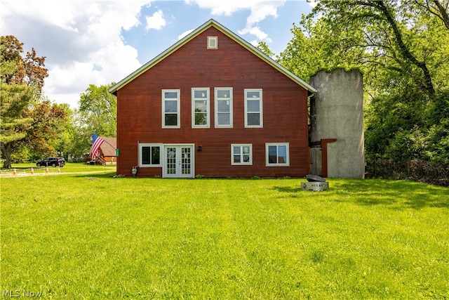 rear view of house featuring french doors and a lawn