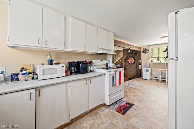 kitchen with custom range hood, wood walls, white cabinets, white appliances, and light tile floors