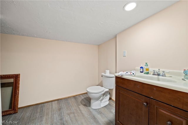 bathroom featuring wood-type flooring, toilet, and vanity