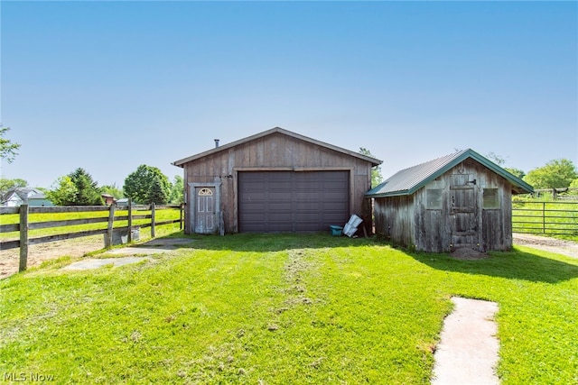 garage with a yard and a rural view