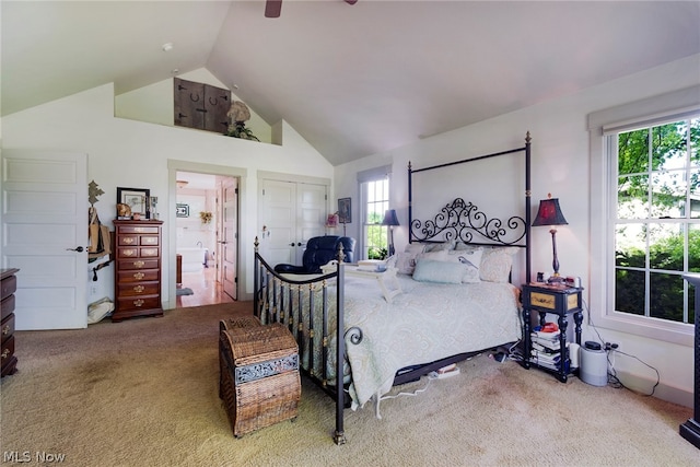 carpeted bedroom with high vaulted ceiling, ceiling fan, and connected bathroom