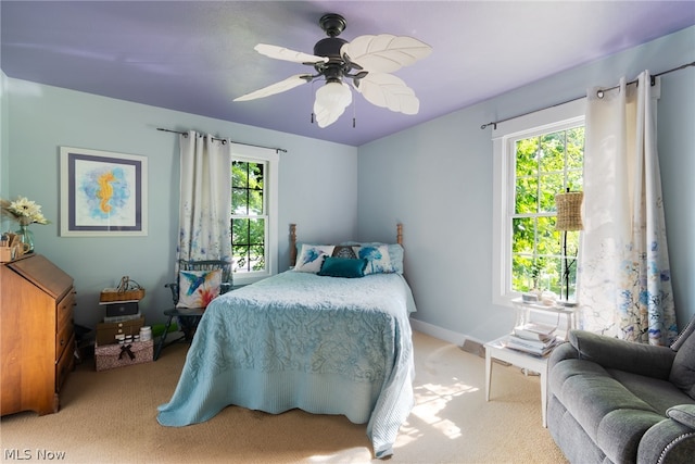 carpeted bedroom with multiple windows and ceiling fan