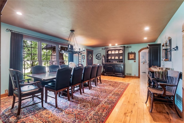 dining room featuring a textured ceiling and light hardwood / wood-style flooring