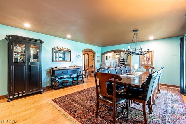 dining space with an inviting chandelier and light hardwood / wood-style flooring