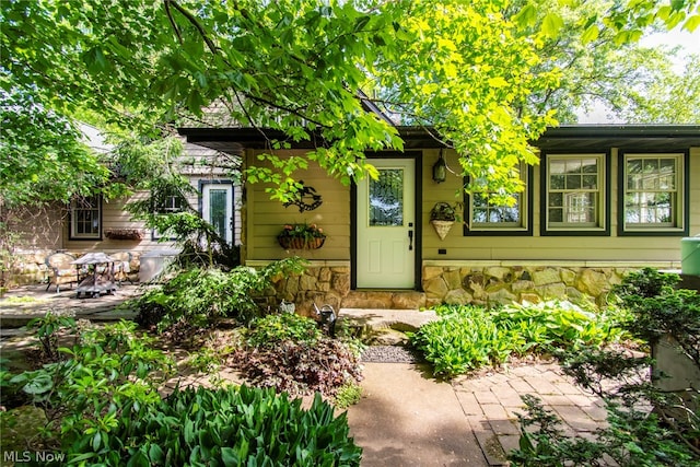 view of exterior entry with a patio