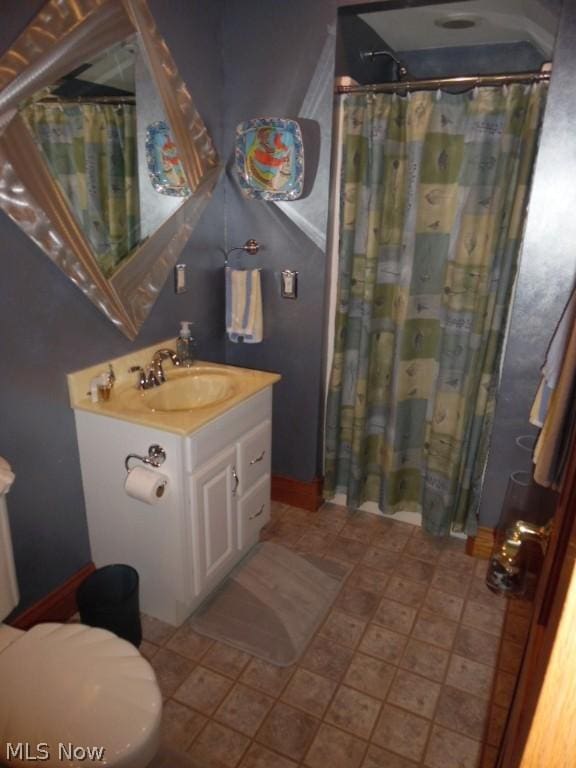 bathroom with vanity, a shower with shower curtain, and toilet