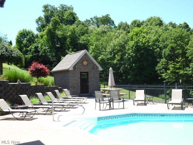 view of pool with a patio area and an outbuilding