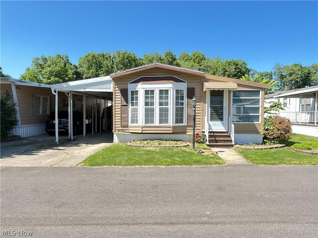 view of front facade with a carport and a front yard