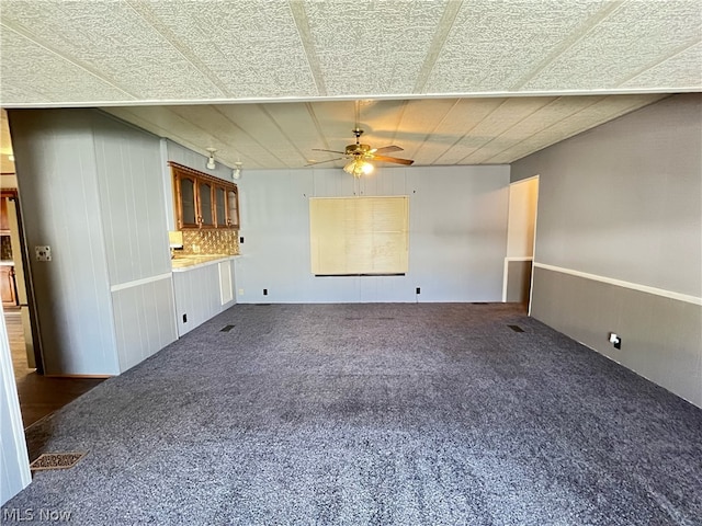 spare room with dark colored carpet and ceiling fan