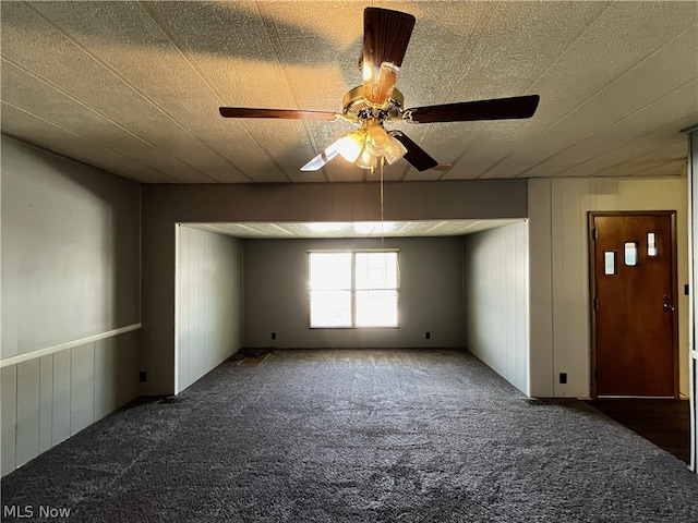 empty room featuring dark colored carpet and ceiling fan