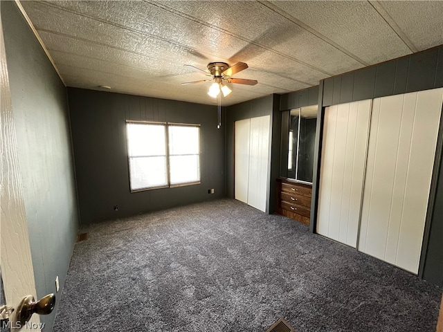 unfurnished bedroom with a textured ceiling, carpet flooring, and ceiling fan