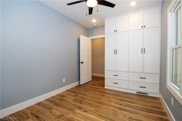 unfurnished bedroom with ceiling fan, light hardwood / wood-style flooring, and multiple windows