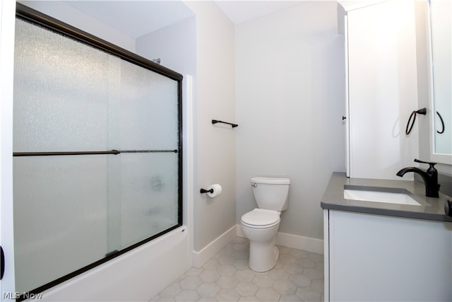 full bathroom featuring tile flooring, oversized vanity, toilet, and bath / shower combo with glass door