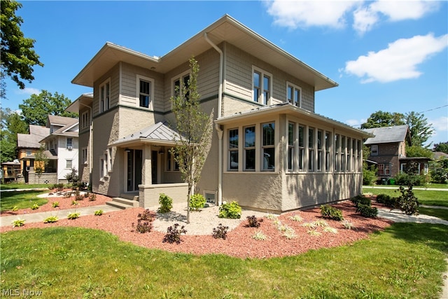 rear view of house featuring a lawn