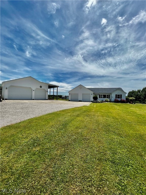 view of front facade with a front yard, a garage, and a carport