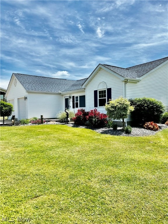 view of side of property featuring a yard and a garage