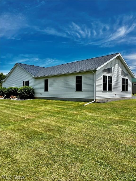 rear view of property featuring a lawn