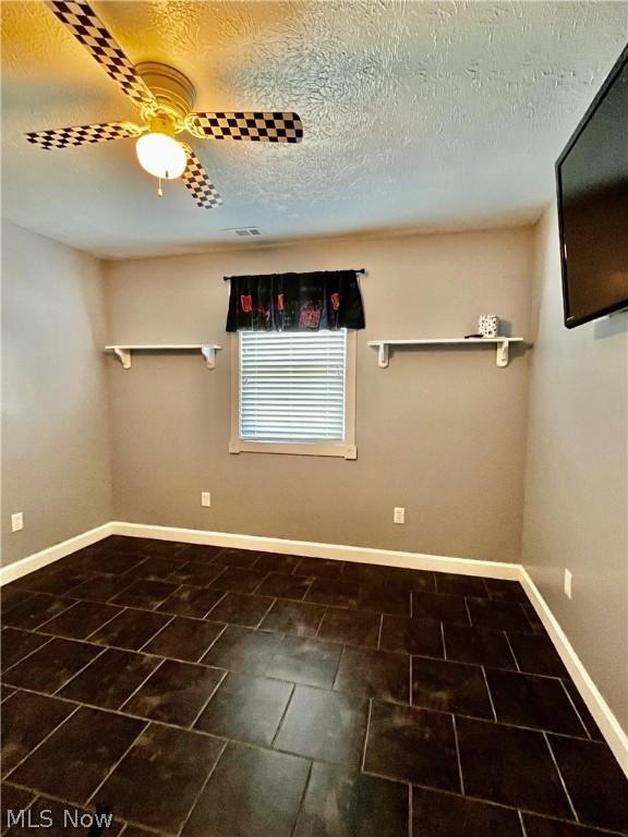 unfurnished room featuring a textured ceiling and ceiling fan