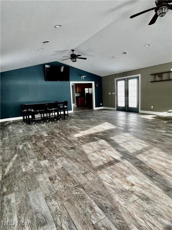 unfurnished living room with hardwood / wood-style flooring, vaulted ceiling, french doors, and ceiling fan