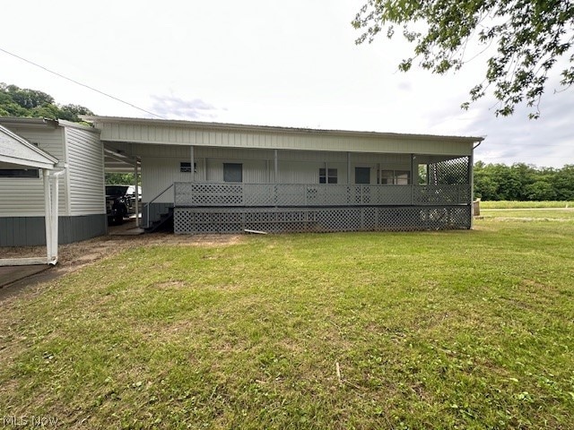 back of property featuring a carport and a lawn