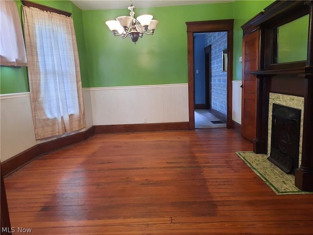 unfurnished dining area with a chandelier and dark hardwood / wood-style floors