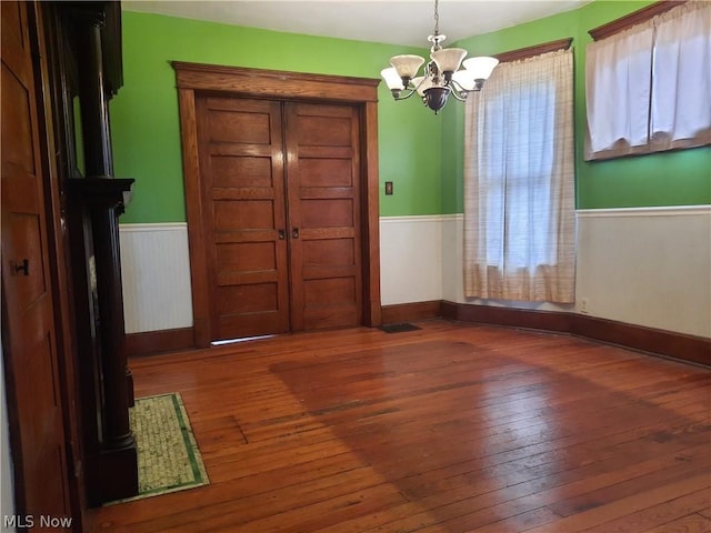 foyer entrance with a notable chandelier and dark hardwood / wood-style floors