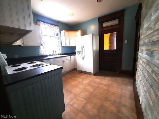 kitchen featuring white cabinets, cooktop, white refrigerator with ice dispenser, and sink